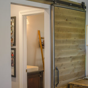 Rustic barn doors separate the family room from the mud room